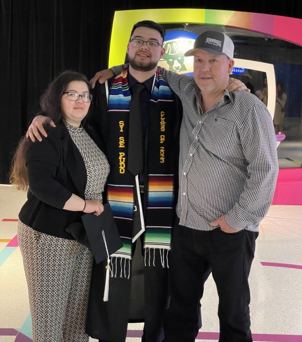 Adrian Mora and his parents at the graduation ceremony. 