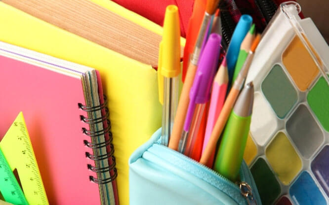 A colorful collection of folders, notebooks, pens, rulers and paint