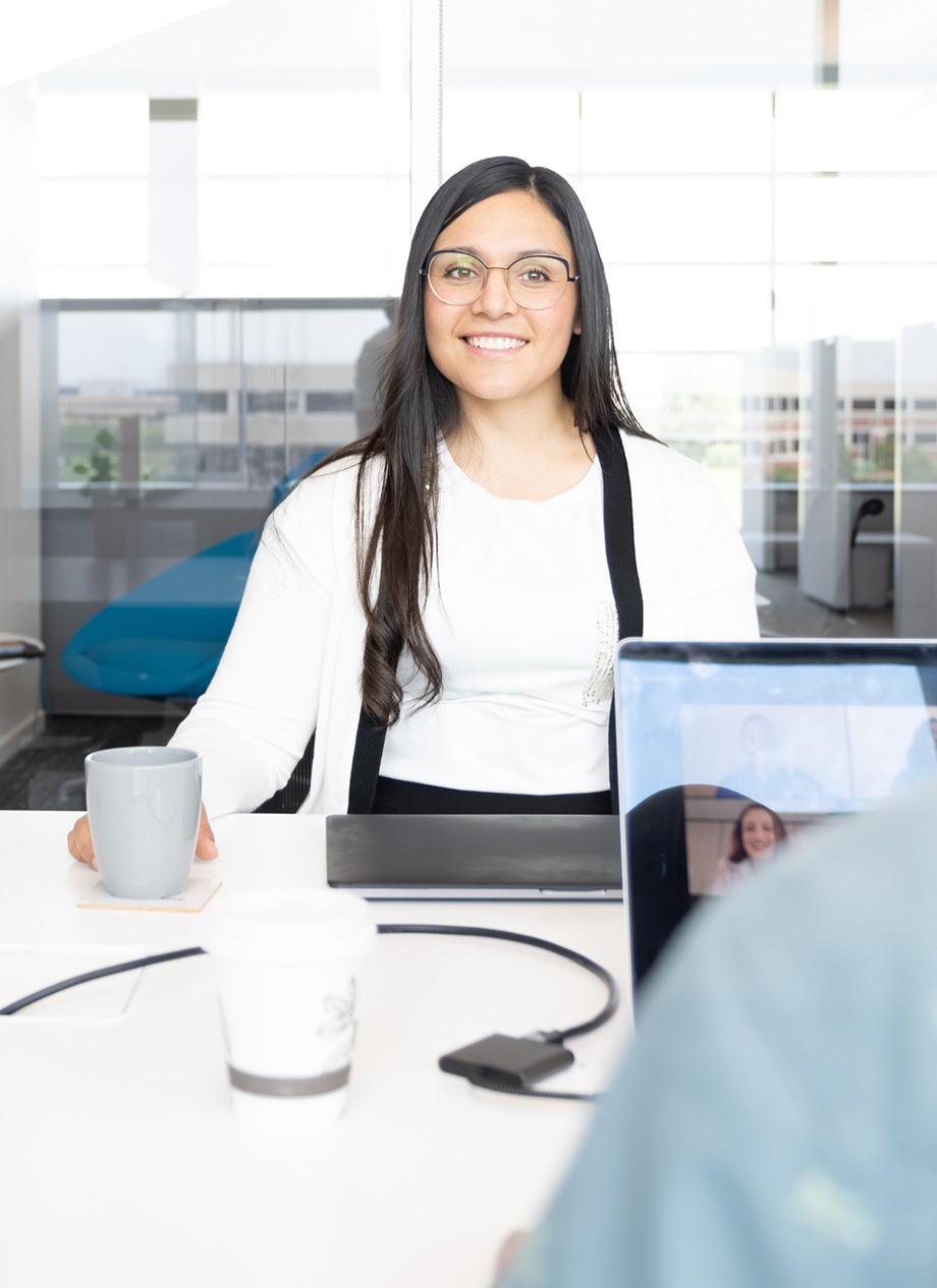 A young woman converses with a co-worker.